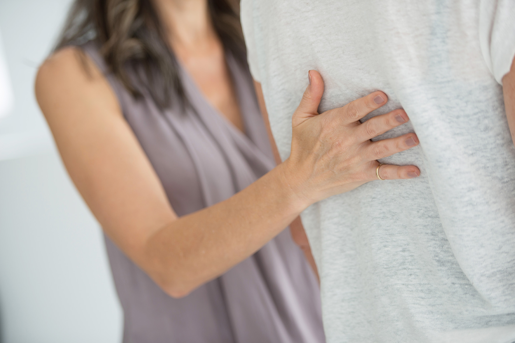 Woman gently holding the back of another person